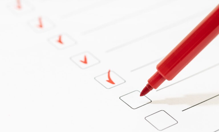 Liste de contrôle cochée au stylo rouge, symbole des vérifications réalisées lors d’un DPE